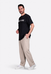 Model wearing beige linen trousers by East Vibe